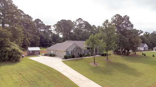 a view of a house with backyard and trees
