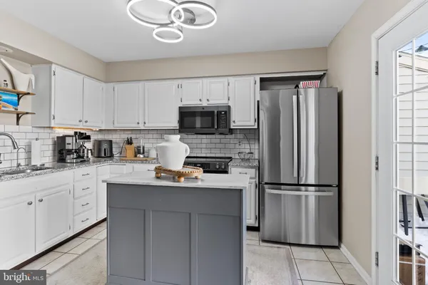 a kitchen with a refrigerator a microwave a sink and cabinets