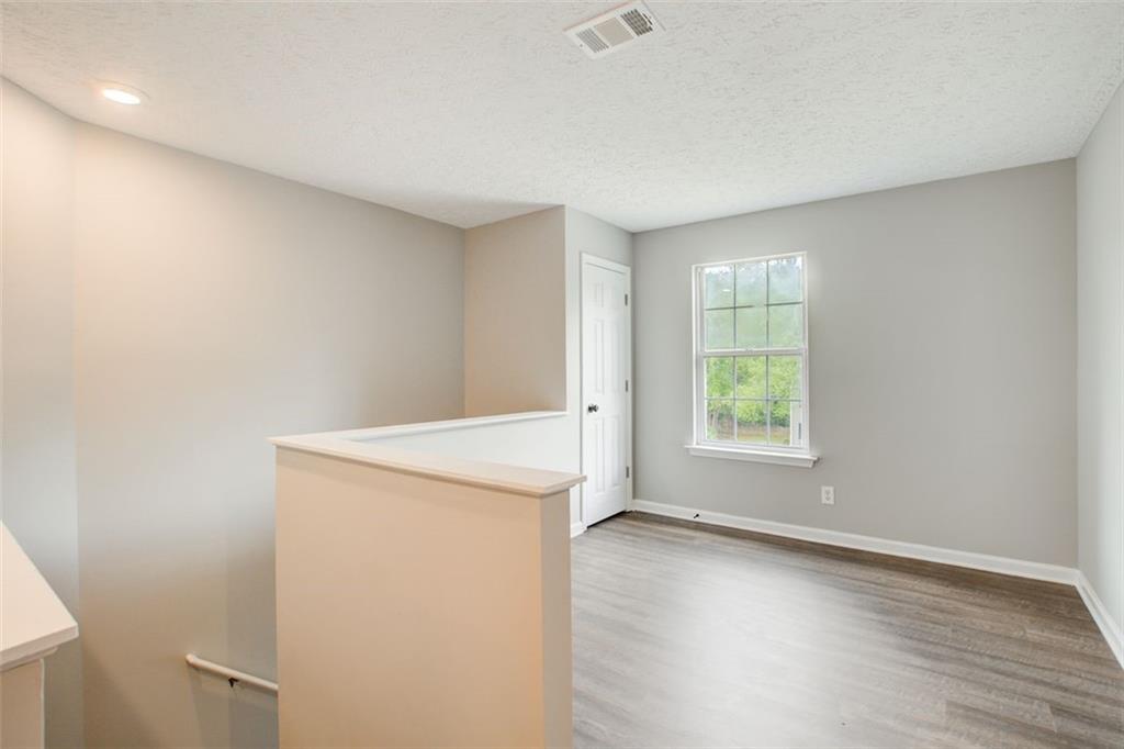 4110 Ridgebrook Bend Cumming, GA 30028 - Photo 22 of 49 an empty room with wooden floor and windows