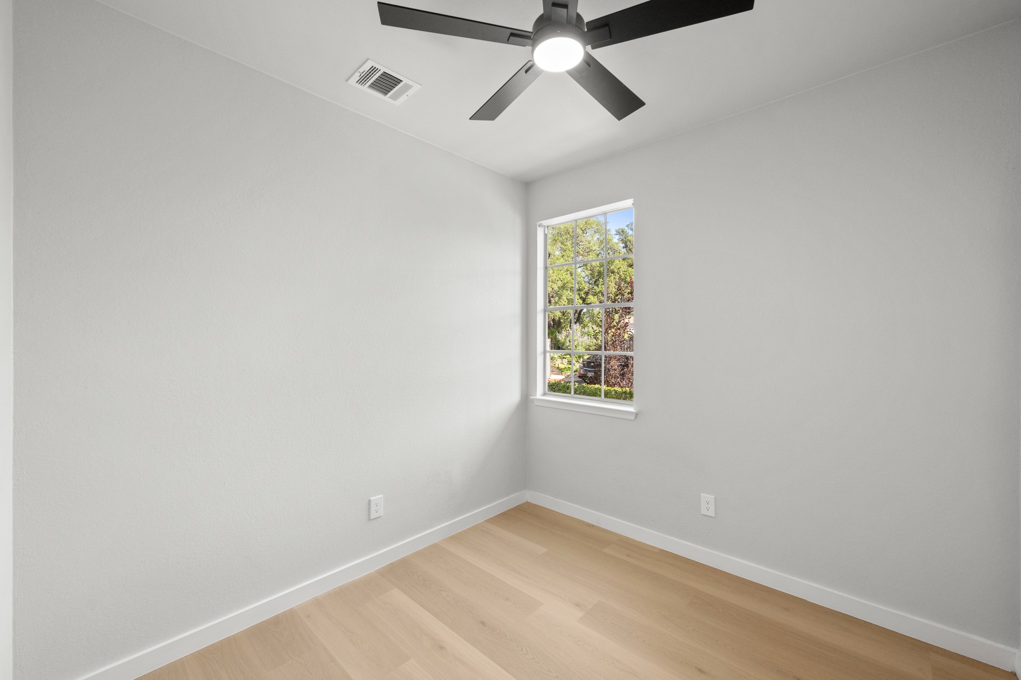 6501 Brush Country Road, Unit 120 Austin, TX 78749 - Photo 18 of 26 Inviting secondary bedroom featuring beautiful wood-finish flooring, abundant natural light, and a spacious closet highlighted by elegant French doors for added charm and character