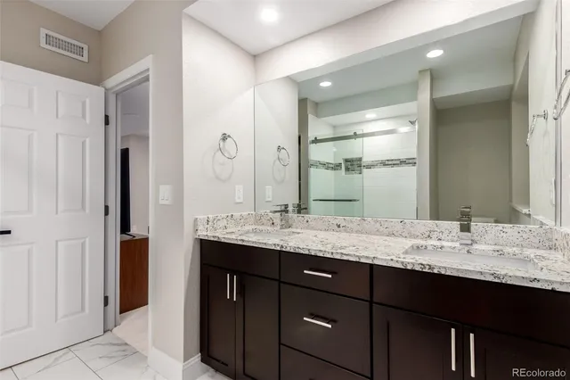 a bathroom with a granite countertop sink and a mirror