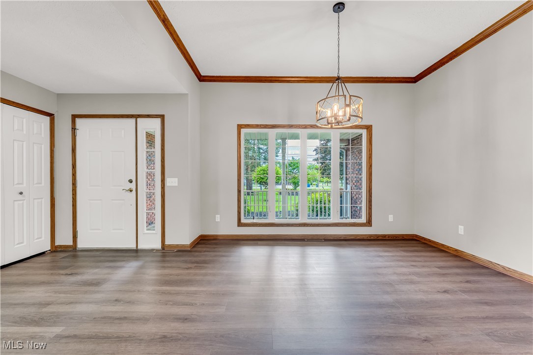 5327 Jaycox Road North Ridgeville, OH 44039 - Photo 5 of 36 Foyer entrance with a chandelier, lvp finished floors, baseboards, and crown molding