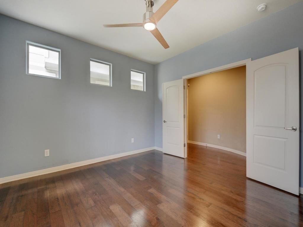 1115 Kinney Avenue, Unit 41 Austin, TX 78704 - Photo 12 of 26 an empty room with wooden floor and windows