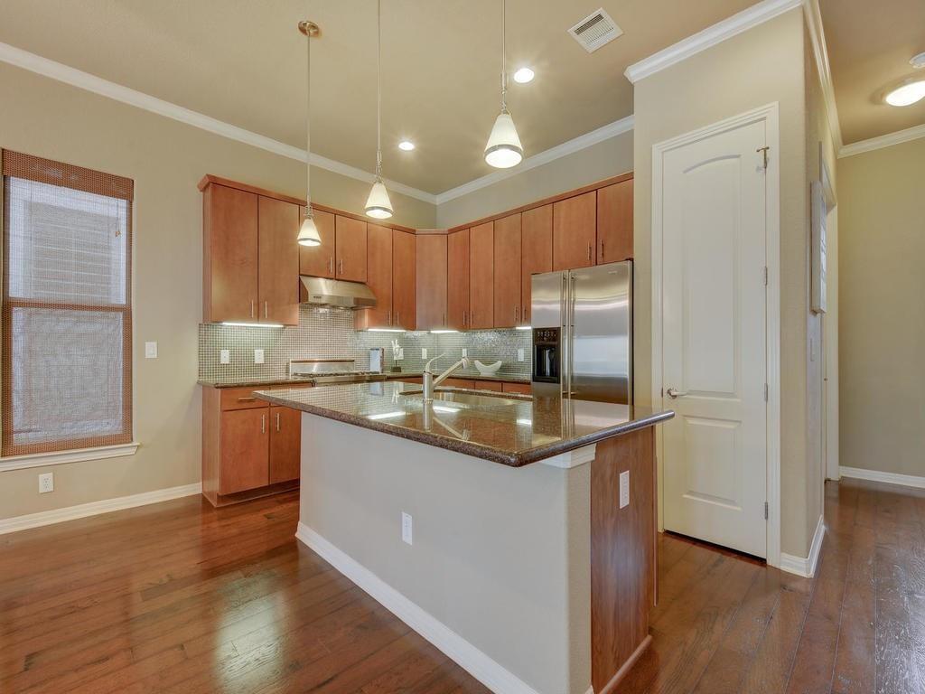 1115 Kinney Avenue, Unit 41 Austin, TX 78704 - Photo 4 of 26 a kitchen with kitchen island granite countertop a sink appliances and cabinets