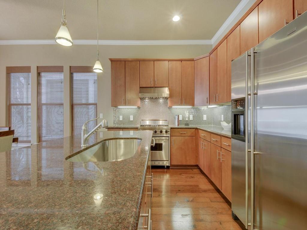 1115 Kinney Avenue, Unit 41 Austin, TX 78704 - Photo 5 of 26 a kitchen with stainless steel appliances granite countertop a refrigerator a sink and a stove