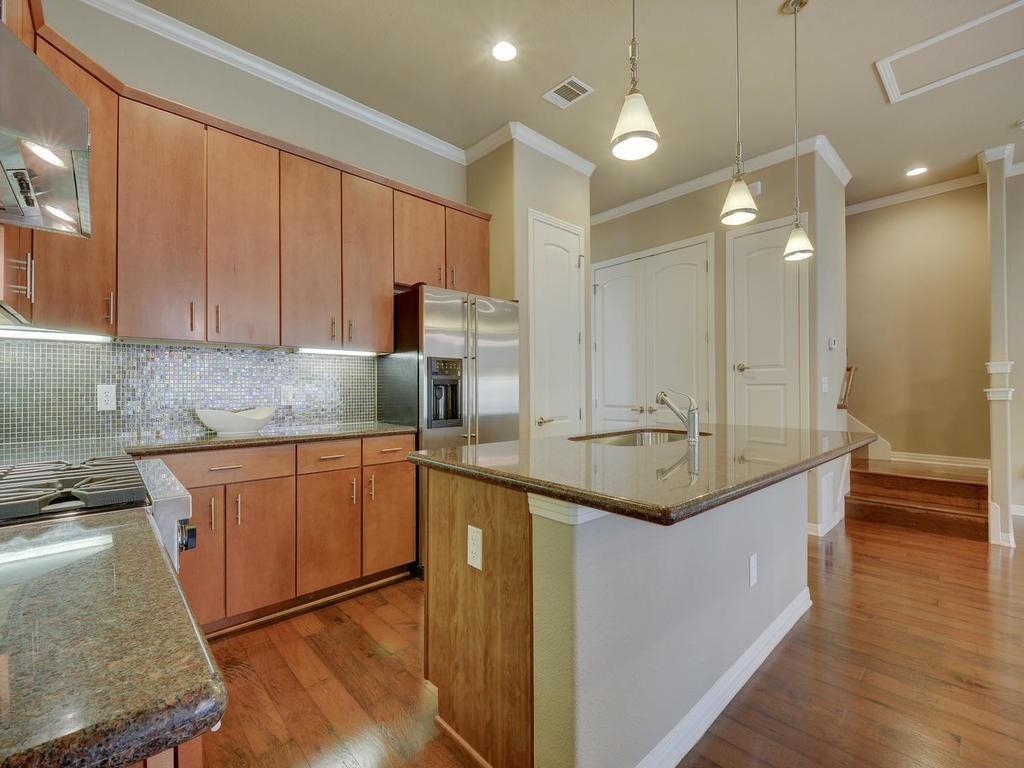 1115 Kinney Avenue, Unit 41 Austin, TX 78704 - Photo 6 of 26 a kitchen with stainless steel appliances granite countertop a sink a stove and a wooden floors
