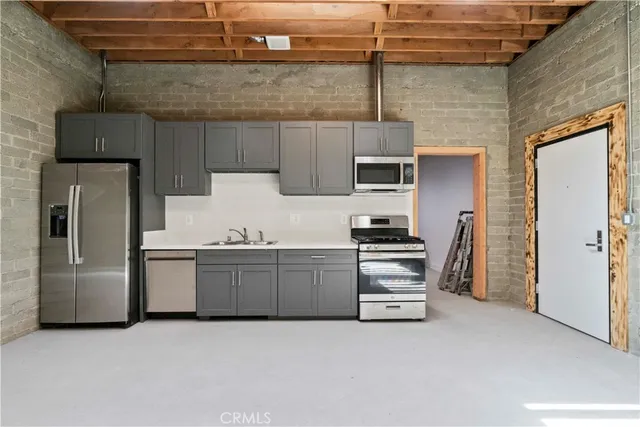 a kitchen with granite countertop a refrigerator and a stove