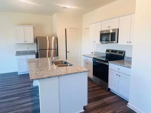 a kitchen with stainless steel appliances granite countertop a sink and microwave