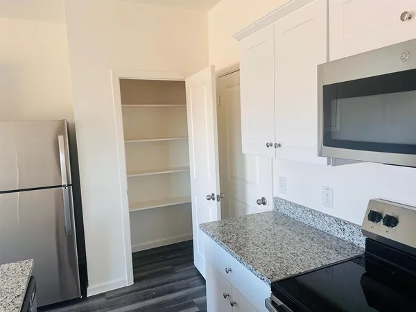 a kitchen with a refrigerator and microwave