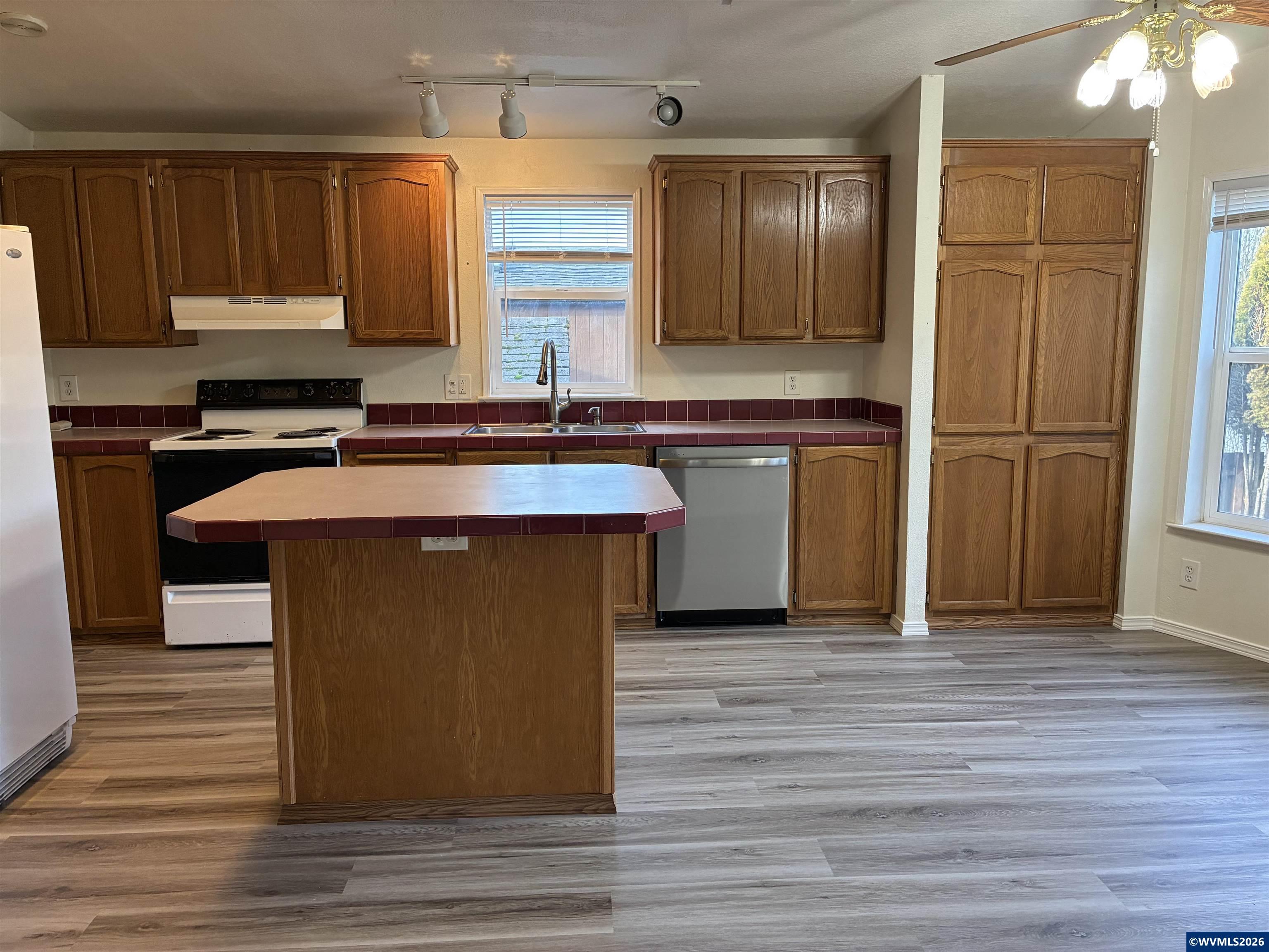 2000 Robins Lane Southeast, Unit 7 Salem, OR 97306 - Photo 5 of 39 a kitchen with kitchen island granite countertop wooden cabinets and a sink