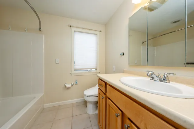 a bathroom with a granite countertop sink a toilet and bathtub