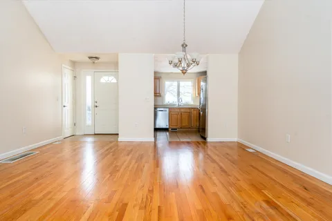 a view of a room with wooden floor and kitchen