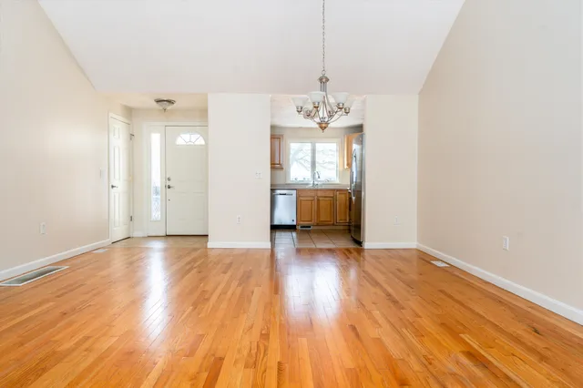 a view of a room with wooden floor and kitchen