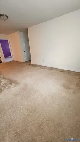 a view of an empty room with a window and closet area