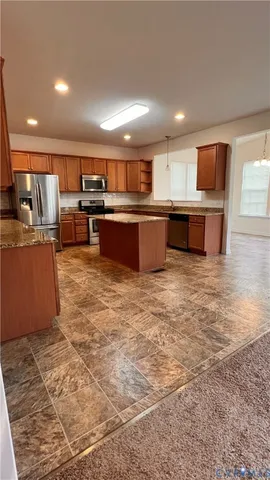 a large kitchen with a large counter top and stainless steel appliances