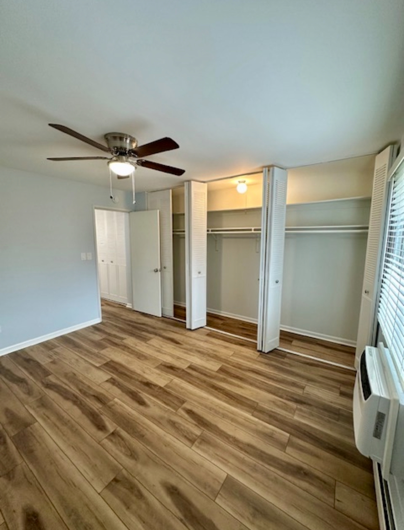3515 Central Road, Unit 103 Glenview, IL 60025 - Photo 13 of 27 a view of a livingroom with wooden floor and a ceiling fan