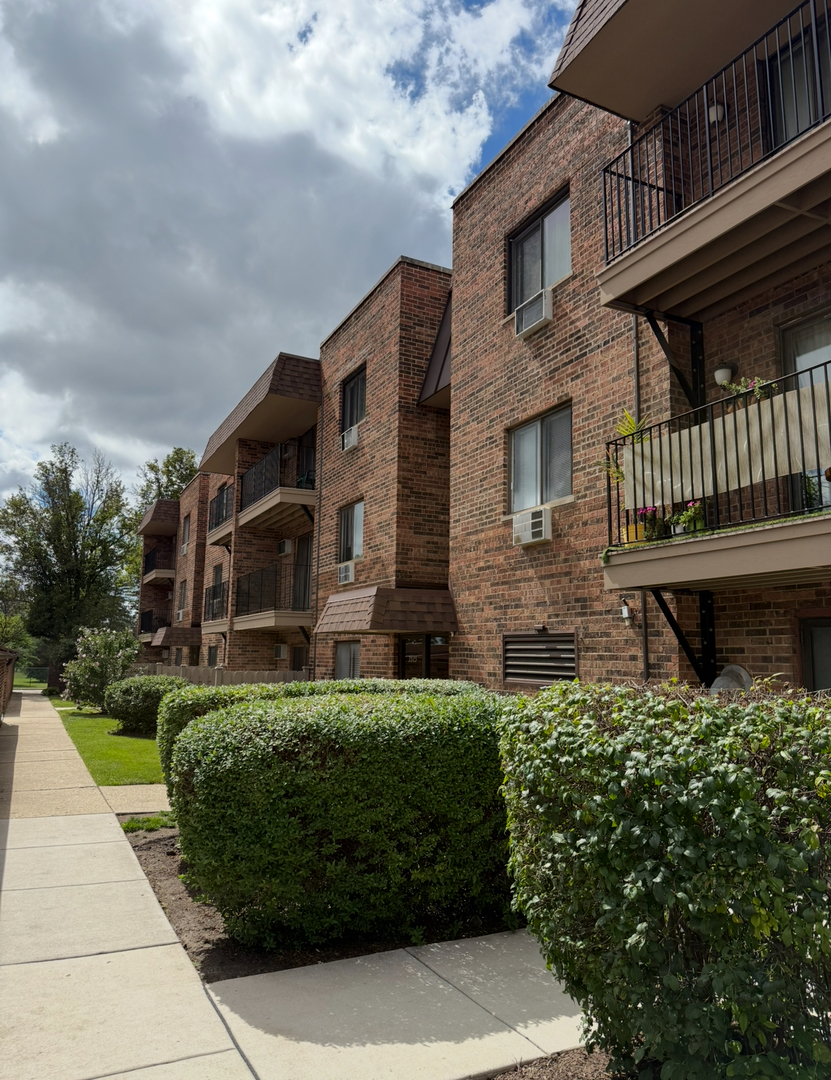 3515 Central Road, Unit 103 Glenview, IL 60025 - Photo 2 of 27 a view of a brick house with a yard