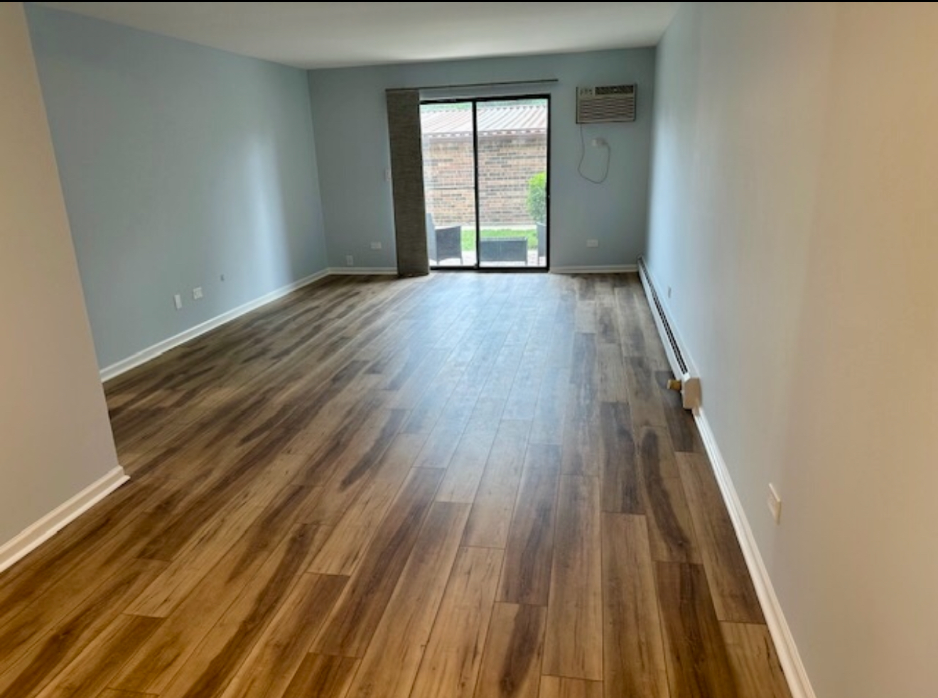 3515 Central Road, Unit 103 Glenview, IL 60025 - Photo 7 of 27 an empty room with wooden floor and windows