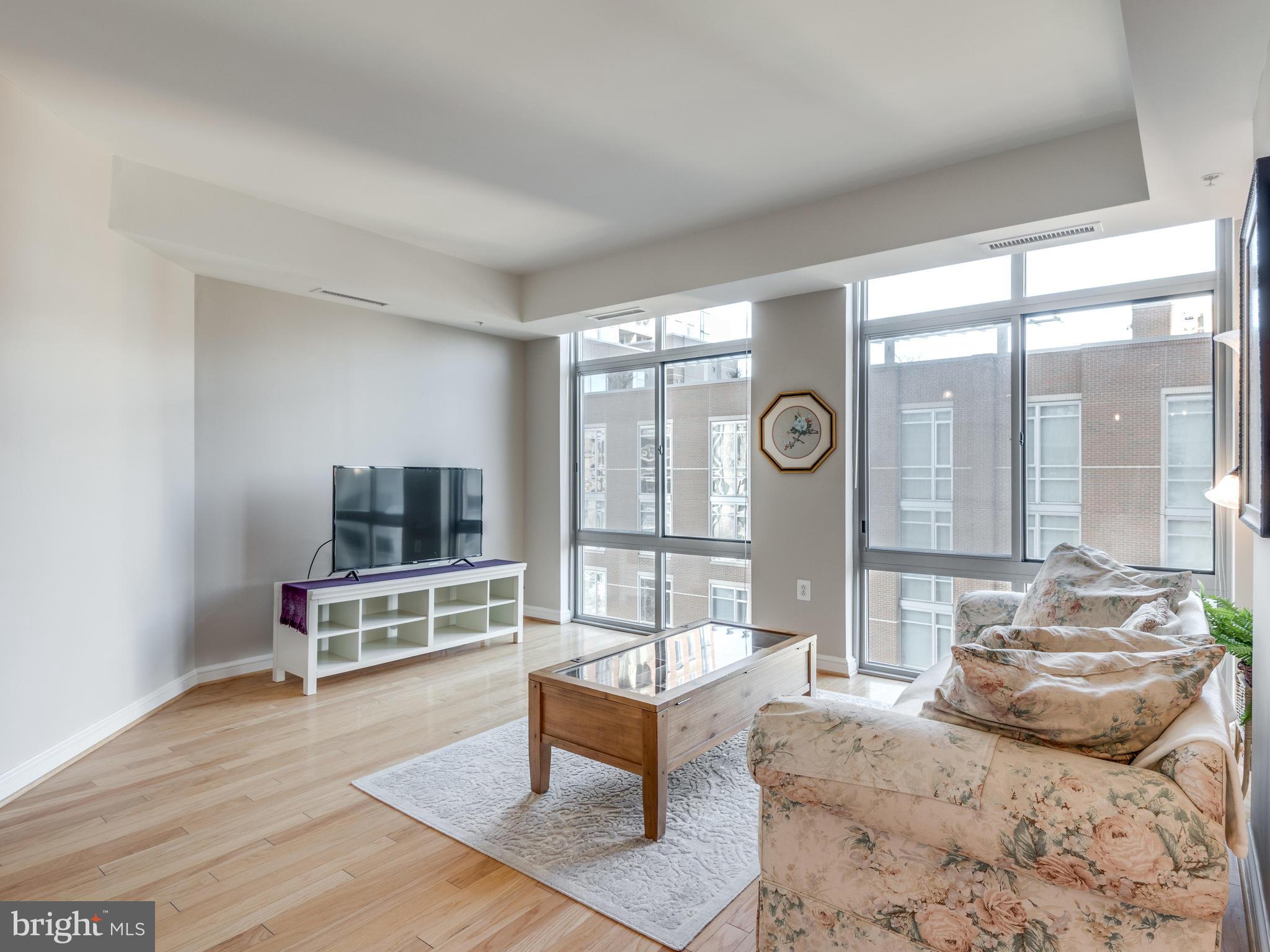 11990 Market Street, Unit 606 Reston, VA 20190 - Photo 6 of 30 Living Room with Floor to Ceiling Windows