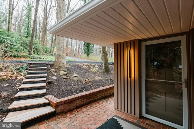 a living room with furniture a fireplace a chandelier and a large window