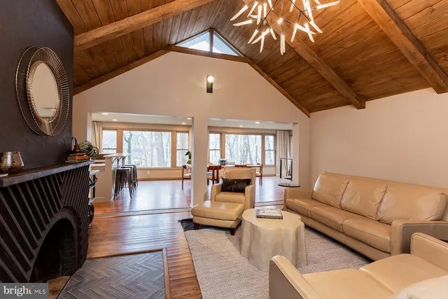 a living room with furniture a fireplace and a chandelier
