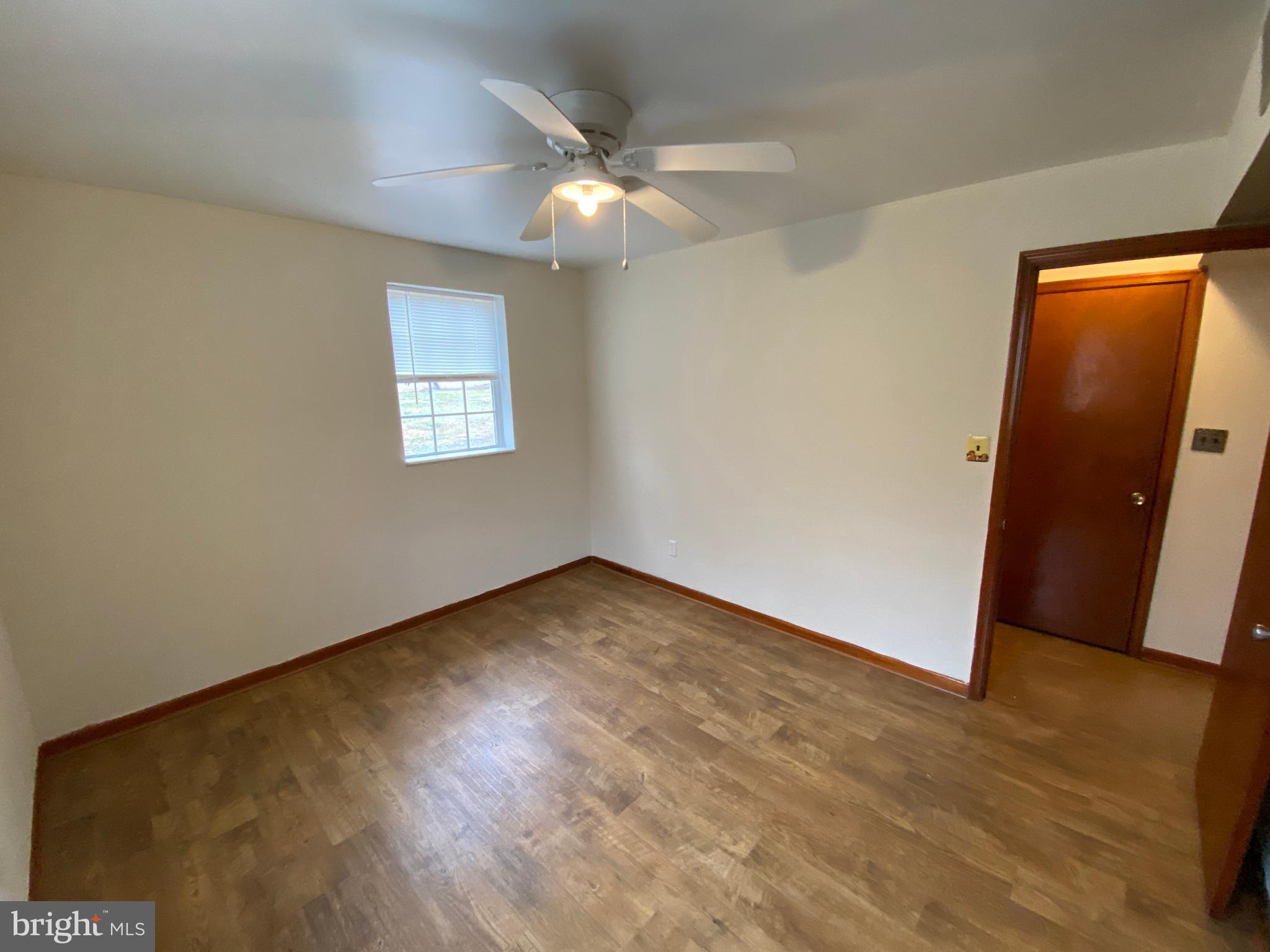 423 Hill Street, Unit 2 Culpeper, VA 22701 - Photo 13 of 18 a view of an empty room with wooden floor and a window