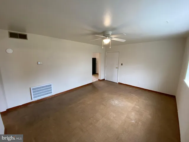 an empty room with a ceiling fan and a window