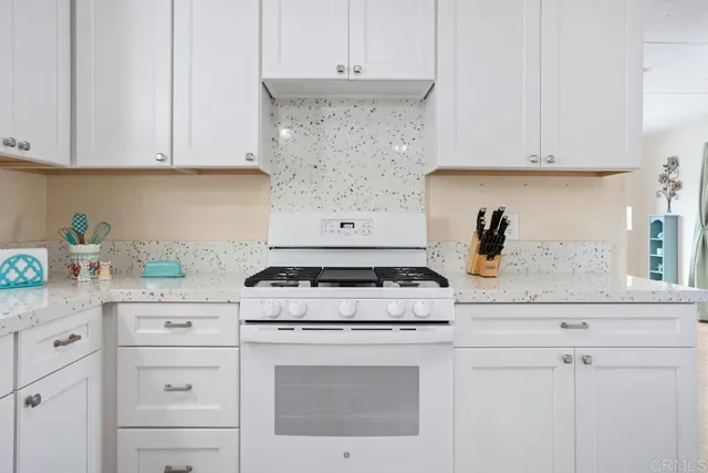 a white stove top oven sitting inside of a kitchen