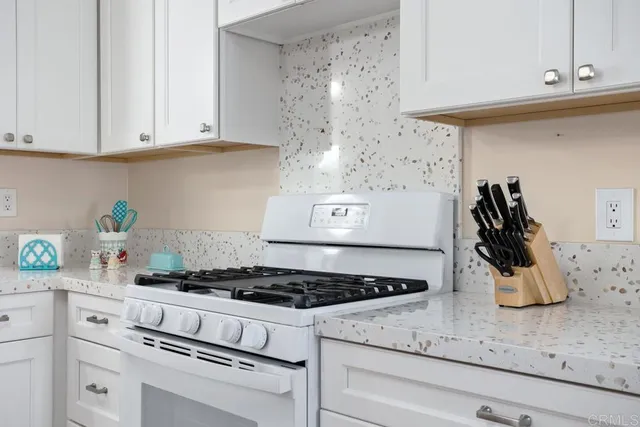 a kitchen with white cabinets and appliances