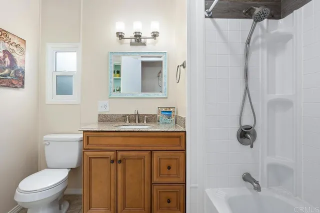 a bathroom with a granite countertop toilet a sink and a bathtub
