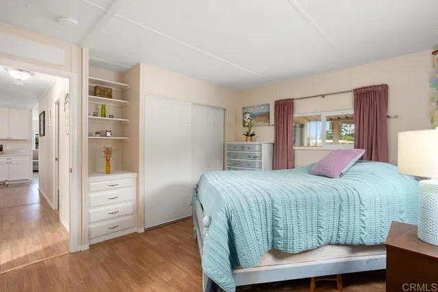 a bedroom with a large bed and wooden floor