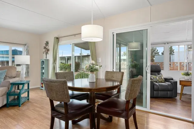 a dining room with furniture a chandelier and wooden floor