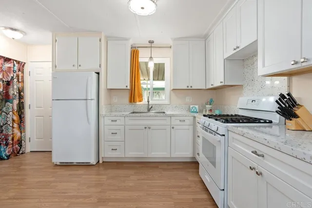 a kitchen with cabinets appliances and a window