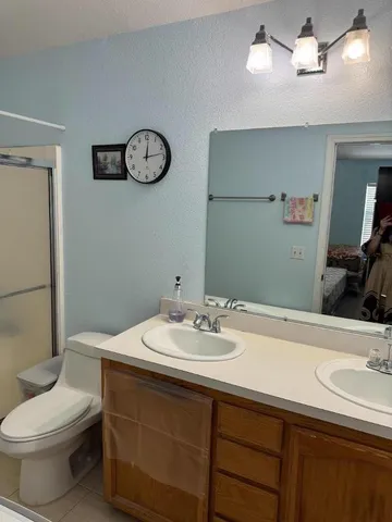 a bathroom with a sink vanity mirror and toilet
