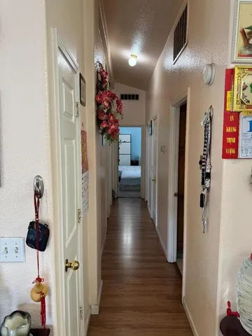 a view of a hallway with wooden floor and closet