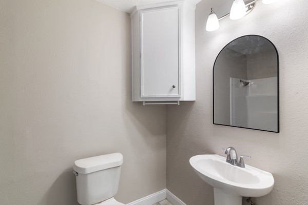 4104 Marsh Street Bryan, TX 77803 - Photo 19 of 26 a bathroom with a toilet a sink and mirror