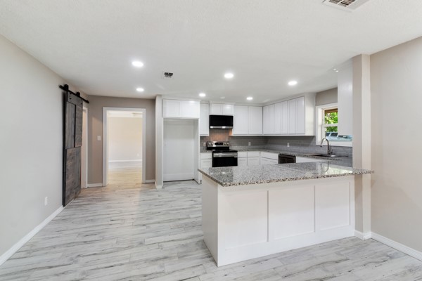 4104 Marsh Street Bryan, TX 77803 - Photo 8 of 26 a large kitchen with stainless steel appliances granite countertop a sink and cabinets