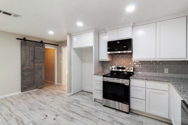 4104 Marsh Street Bryan, TX 77803 - Photo 10 of 26 a kitchen with stainless steel appliances granite countertop a stove and a refrigerator