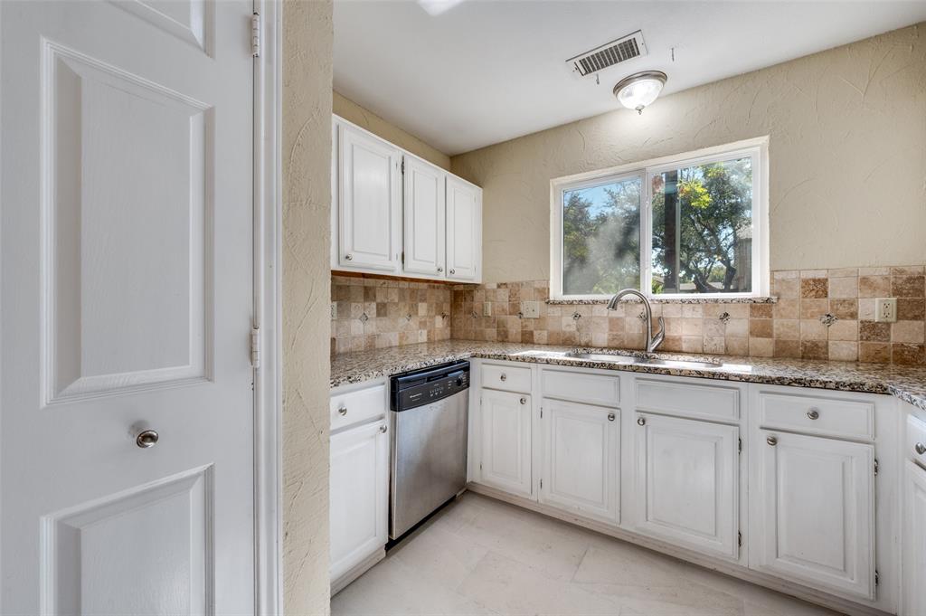 5565 Preston Oaks Road, Unit 130 Dallas, TX 75254 - Photo 12 of 25 Kitchen with a textured wall, white cabinets, stainless steel dishwasher, light stone counters, and decorative backsplash