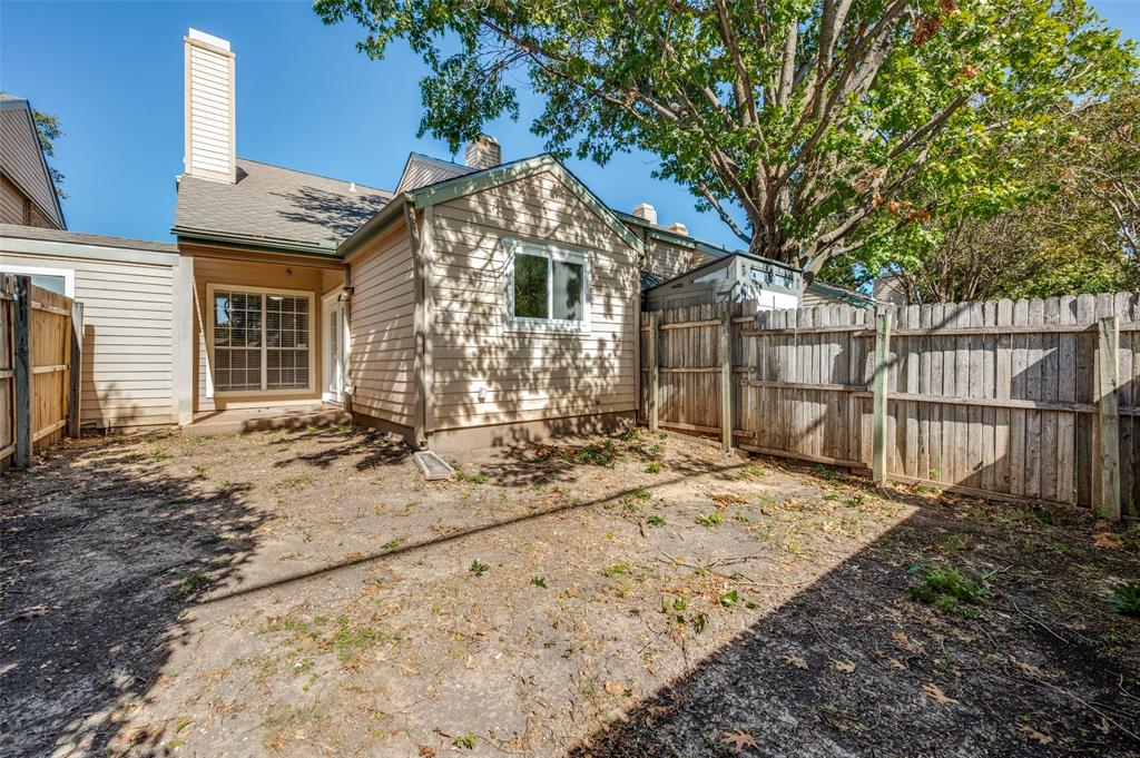 5565 Preston Oaks Road, Unit 130 Dallas, TX 75254 - Photo 24 of 25 Rear view of house with a fenced backyard and a chimney