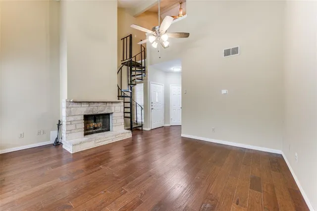 a view of a livingroom with wooden floor a fireplace and a window