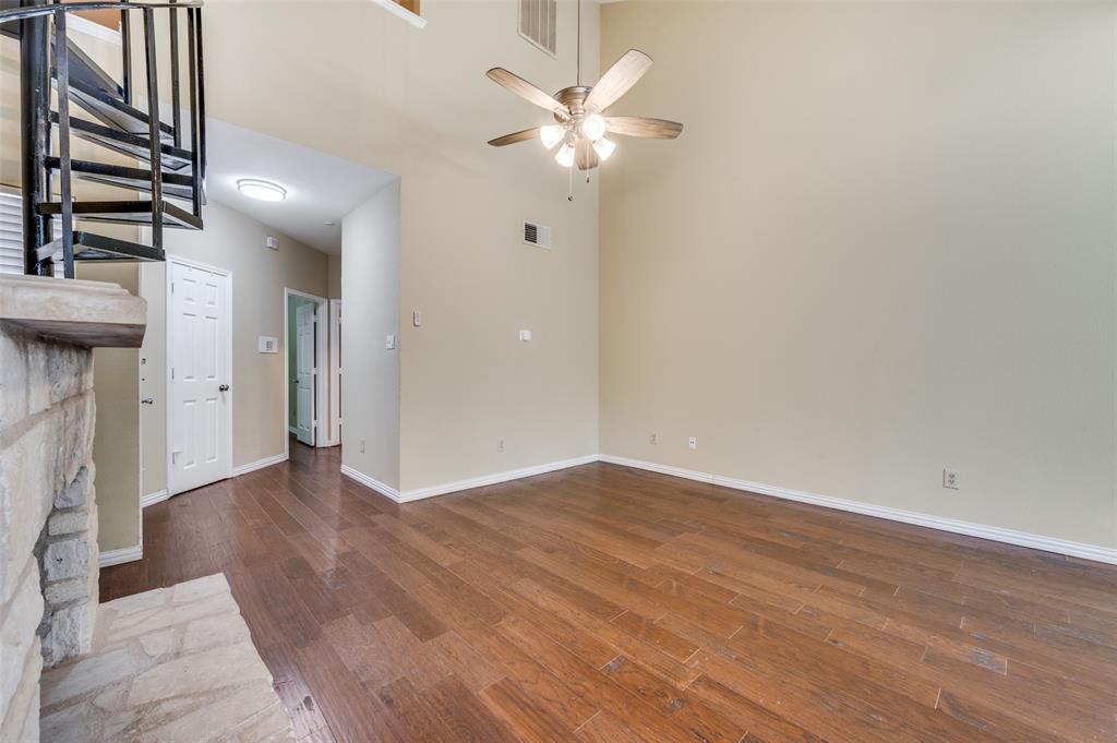 5565 Preston Oaks Road, Unit 130 Dallas, TX 75254 - Photo 6 of 25 Unfurnished living room with dark wood-style flooring, a towering ceiling, and a ceiling fan
