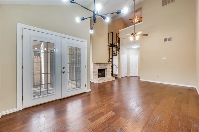 a view of a hallway with wooden floor and a bathroom