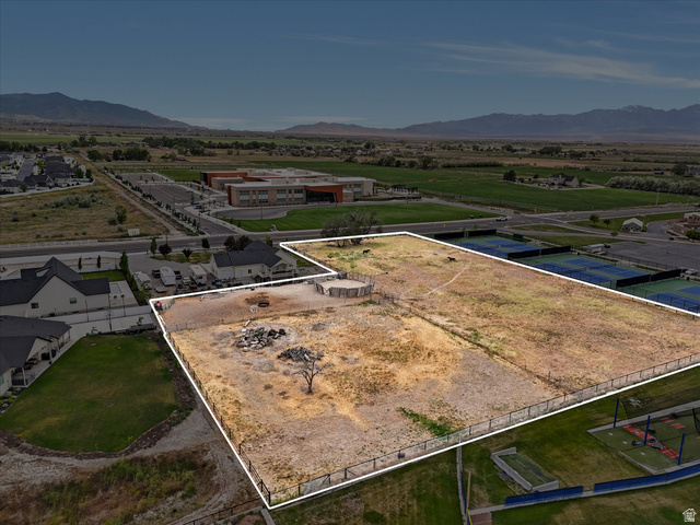 Expansive open land parcel featuring perimeter fencing, an interior fenced area, and a single mature tree