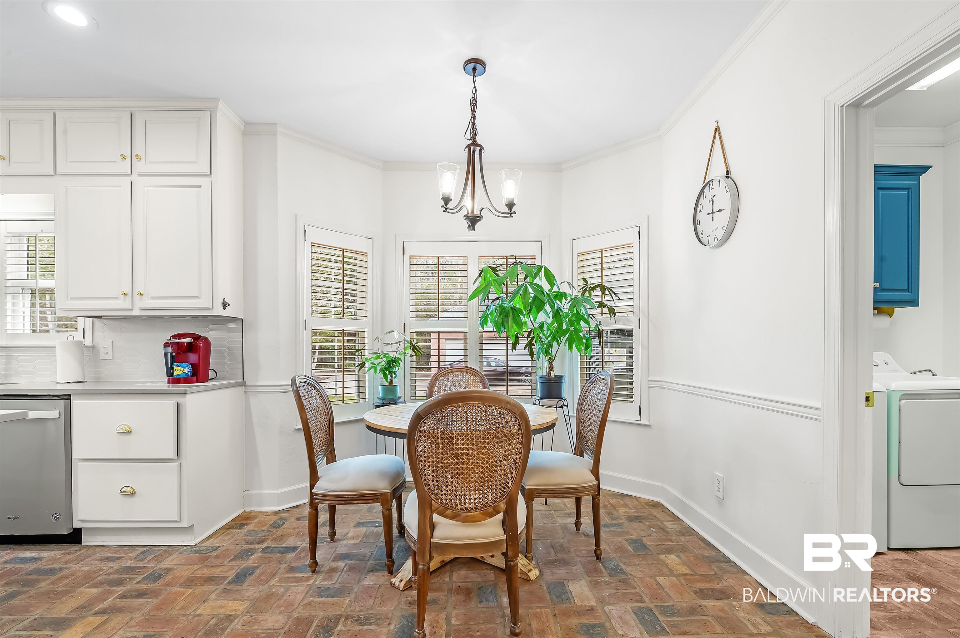 8915 Bay Point Drive Elberta, AL 36530 - Photo 45 of 74 Dining room featuring brick floor, crown molding, a chandelier, washer and dryer, and baseboards