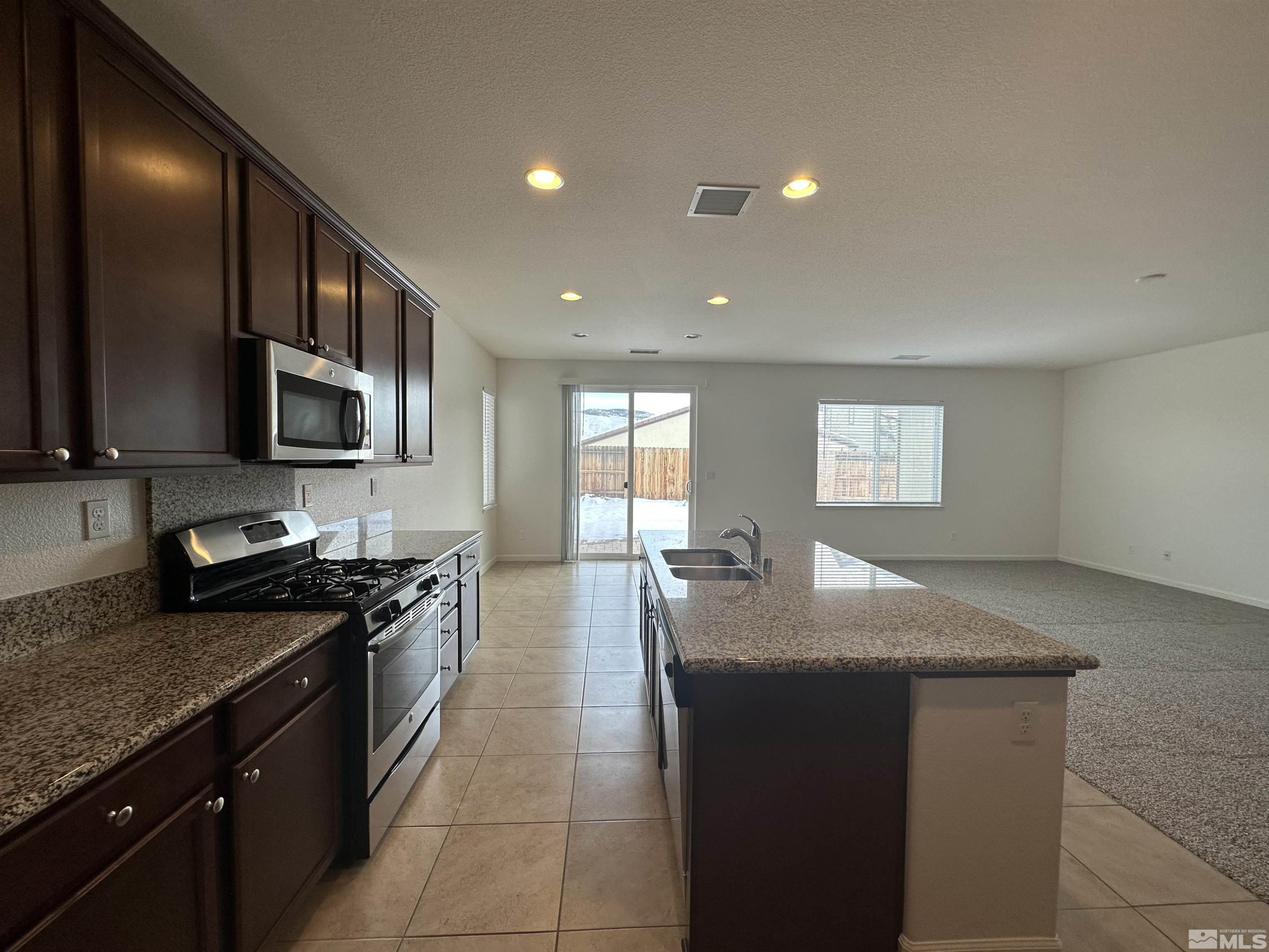 1960 Dutch Draft Drive Reno, NV 89521 - Photo 13 of 23 a kitchen with stainless steel appliances granite countertop a sink a stove top oven a counter space and cabinets