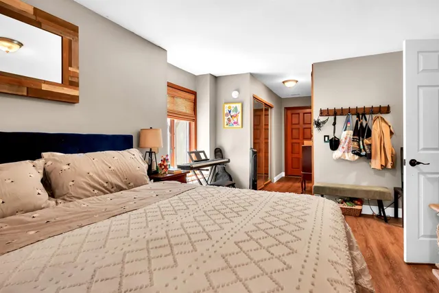 a bedroom with a large bed and a flat tv screen on dresser