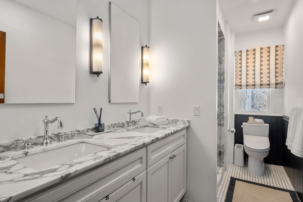 16 Prescott Street Newton, MA 02460 - Photo 16 of 29 a bathroom with a granite countertop sink a toilet and a mirror