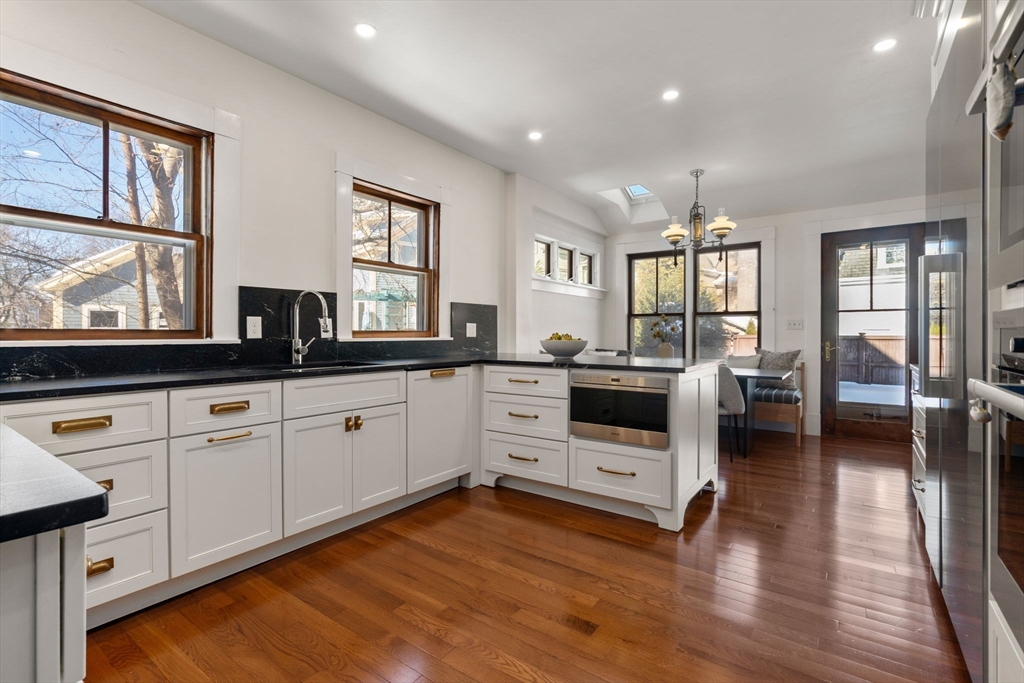 16 Prescott Street Newton, MA 02460 - Photo 2 of 29 a kitchen with stainless steel appliances white cabinets and wooden floors