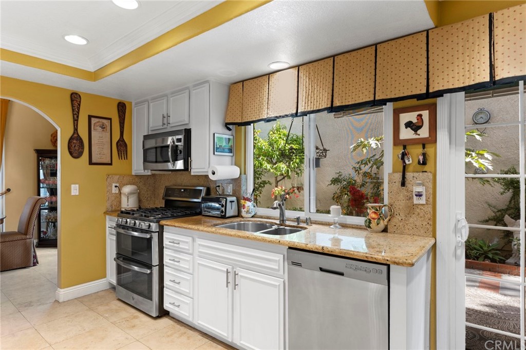 15 Calandria Irvine, CA 92620 - Photo 12 of 49 a kitchen with stainless steel appliances granite countertop a stove a sink and a refrigerator